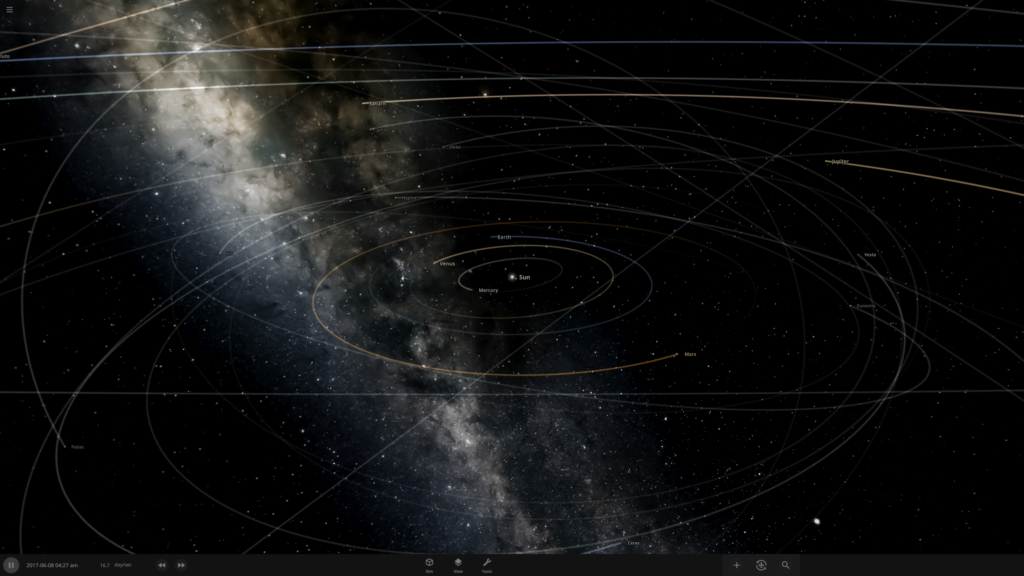 A screenshot from Universe Sandbox showing a stylized view of the Solar System. In the center, a bright white Sun is surrounded by thin colored lines representing the orbits of Mercury, Venus, Earth, and Mars. Farther out, fainter lines trace the elliptical paths of larger planets and numerous small objects. The background features the Milky Way’s faint, cloudy band of light and a multitude of distant stars scattered across the darkness of space.